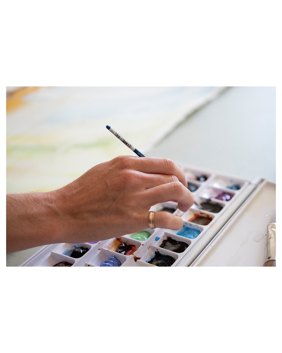 artist-hand-dipping-paint-brush